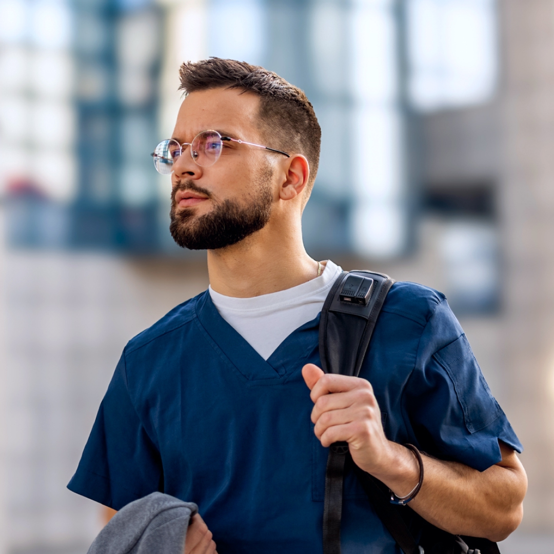 A male nurse looking upwards intently.